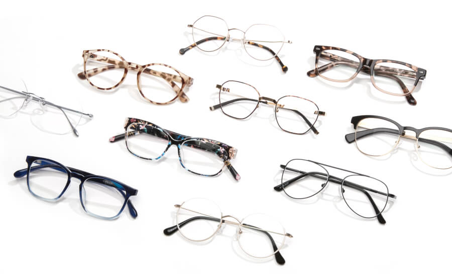 Various styles of eyeglasses arranged on a white background, including tortoiseshell and metal frames.