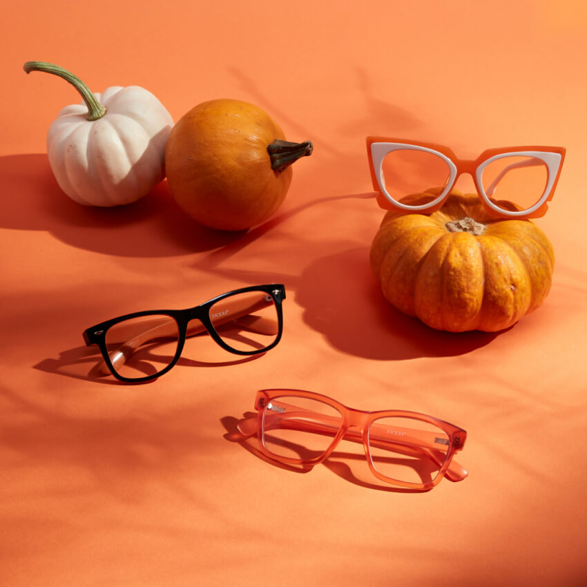 Three pairs of prescription eyeglasses with pumpkins on an orange background.