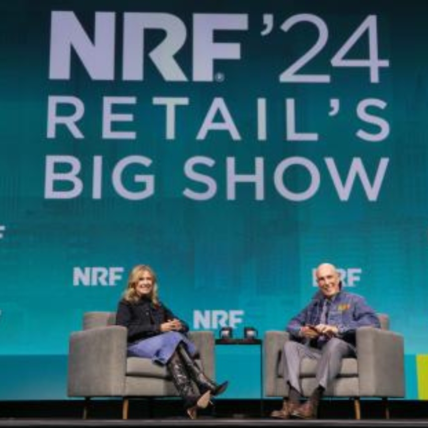 NRF '24 RETAIL'S BIG SHOW. Two people seated on stage in armchairs, engaged in discussion.