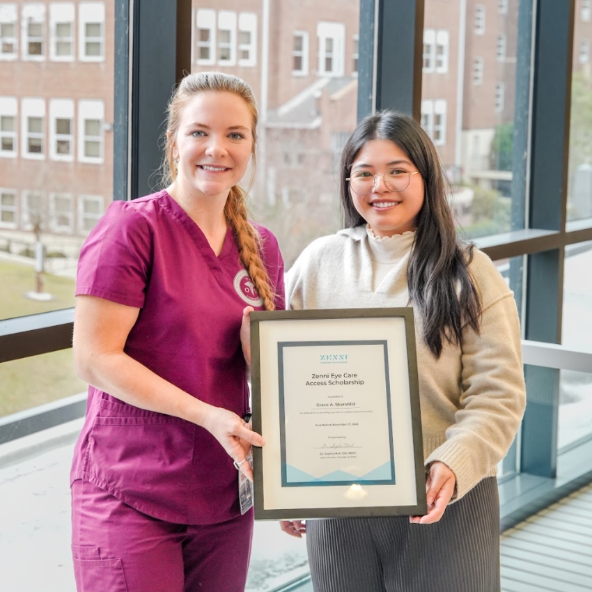 Two people holding a framed Zenni Eye Care Access Scholarship certificate awarded to Grace A. Shahrbafi.