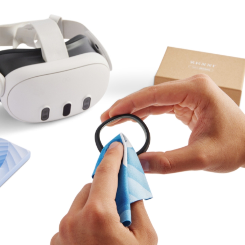 Hands cleaning VR headset lens with a microfiber cloth.