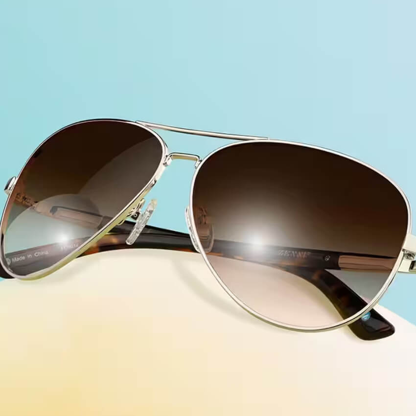 Silver aviator sunglasses with brown gradient lenses. Text on the inner arm reads, "ZENNI."