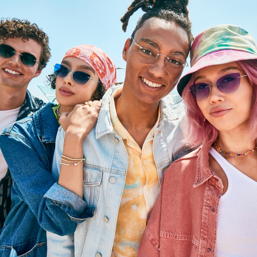 Group wearing colorful, trendy sunglasses and casual clothing, including denim jackets and tie-dye accessories.