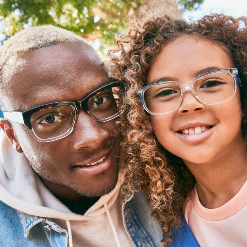 Two people wearing stylish eyeglasses, one with black frames and the other with clear blue frames.