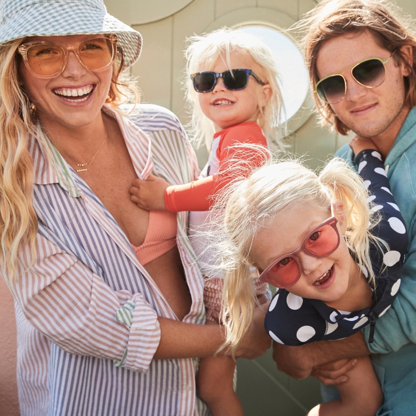 Family wearing colorful sunglasses from J.Crew with various lens styles, enjoying a sunny day together.