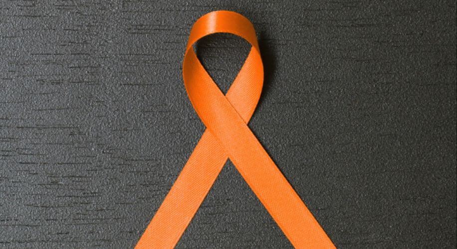 Orange awareness ribbon on a dark textured background.