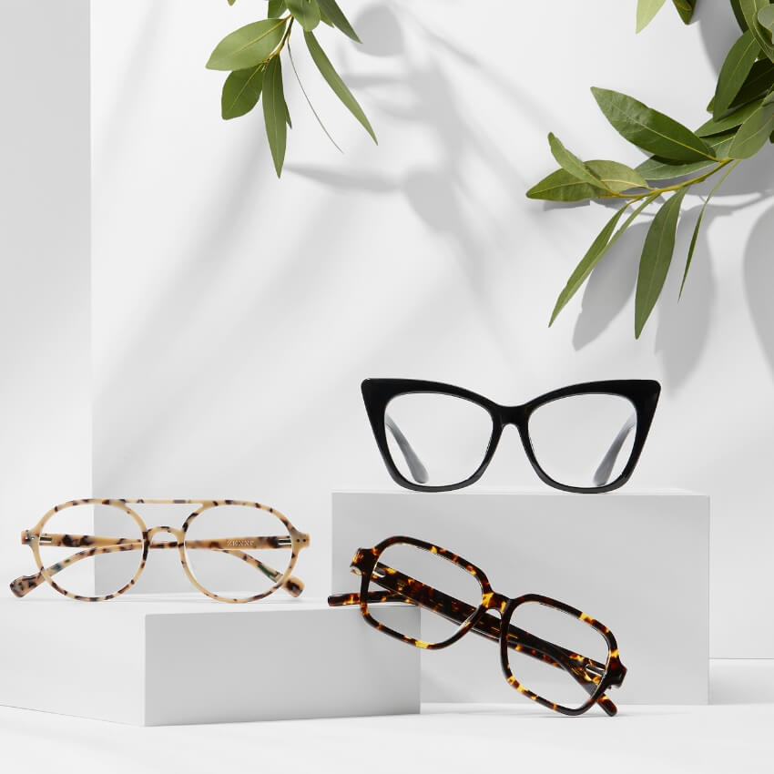 Three pairs of eyeglasses: black cat-eye, round tortoiseshell, and rectangular tortoiseshell.