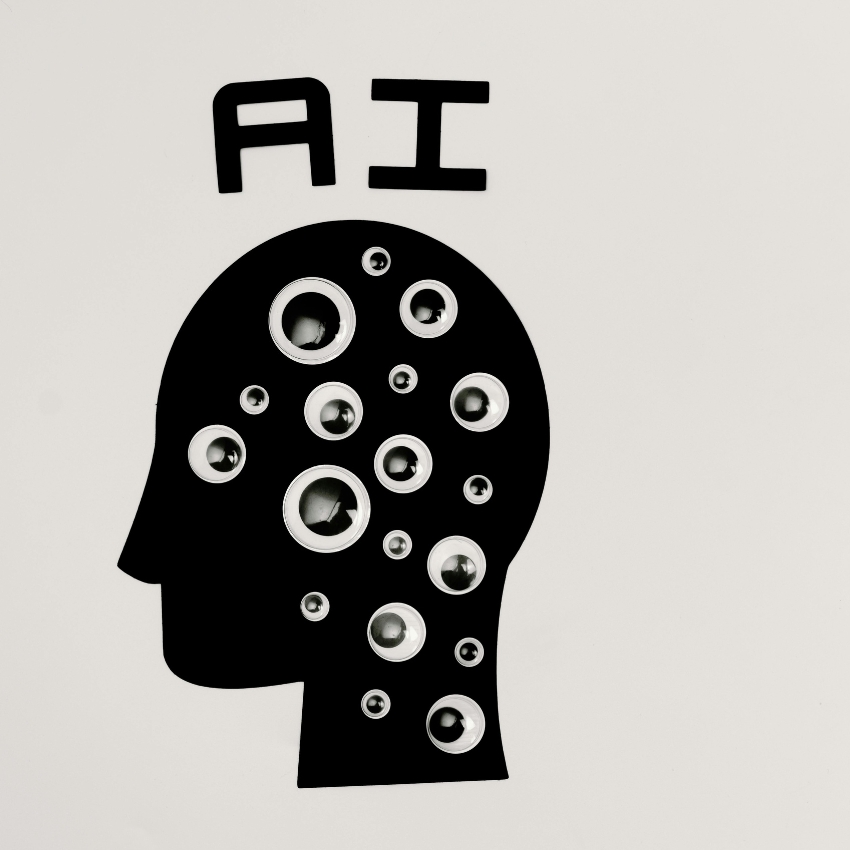 Silhouette of a head with multiple googly eyes and the text "AI" above the head.