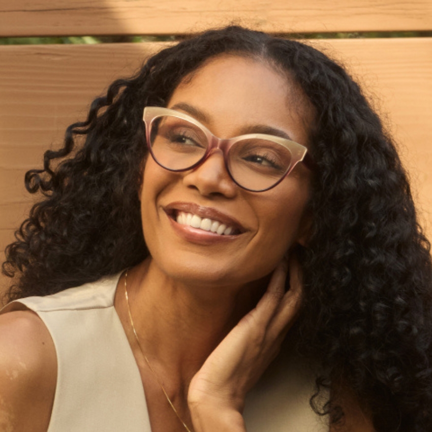 Woman wearing red semi-transparent cat-eye glasses.