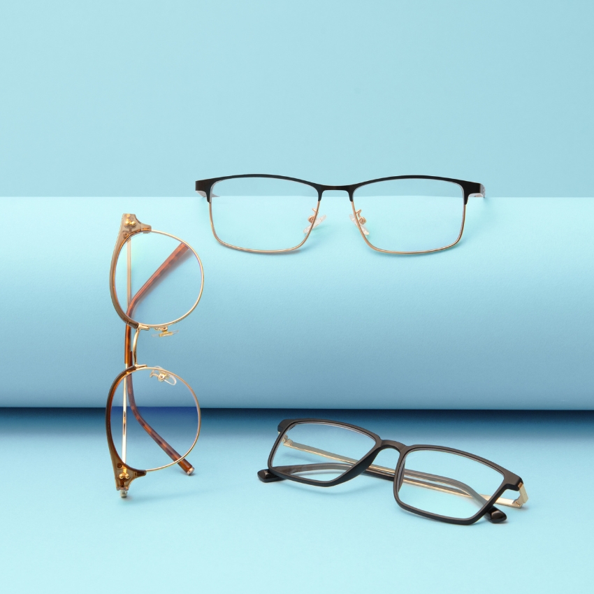 Three pairs of eyeglasses with various frame styles and colors on a blue background.