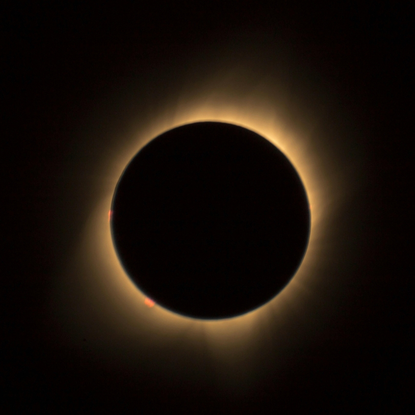 Total solar eclipse with the moon completely covering the sun, creating a bright corona around the darkened solar disk.