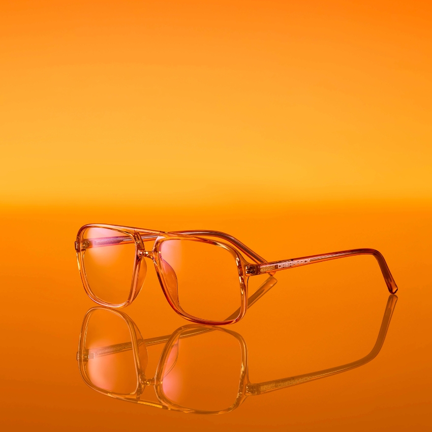 Orange sunglasses with reflective lenses on a matching orange surface.