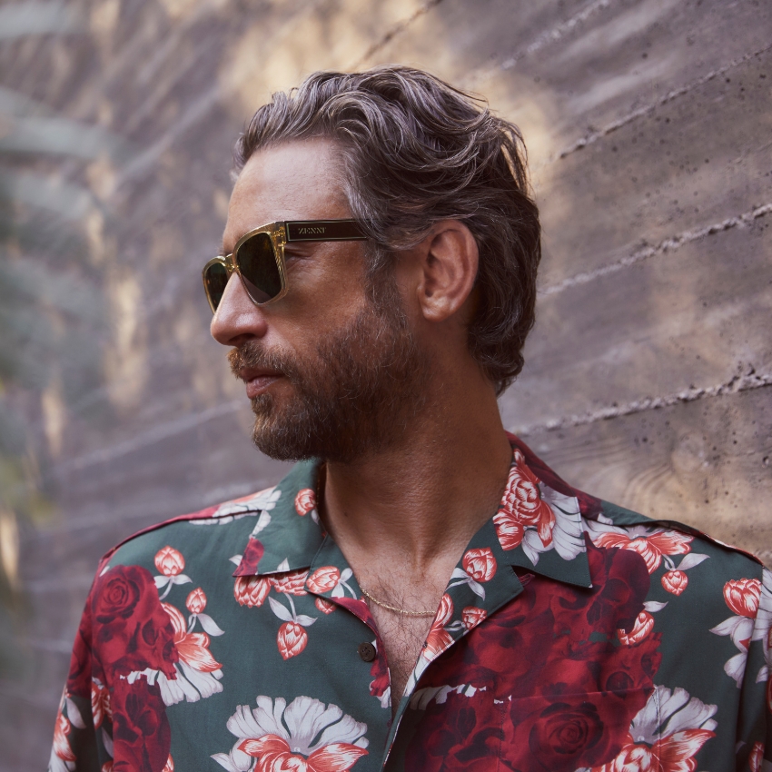 Person wearing VANNY sunglasses and a green and red floral shirt.