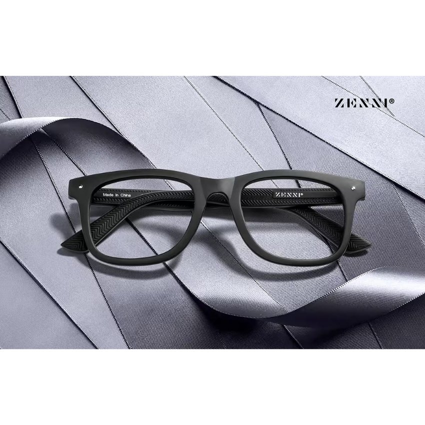 Black-rimmed eyeglasses with text "ZENNI®" on the temple and "Made in China" on the inside hinge.