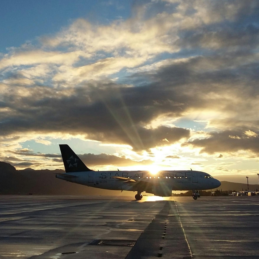 Airplane on the ground during sunset with "STAR ALLIANCE" text partially visible on the aircraft.