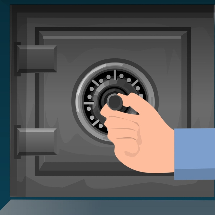 Hand turning dial on a grey safe.