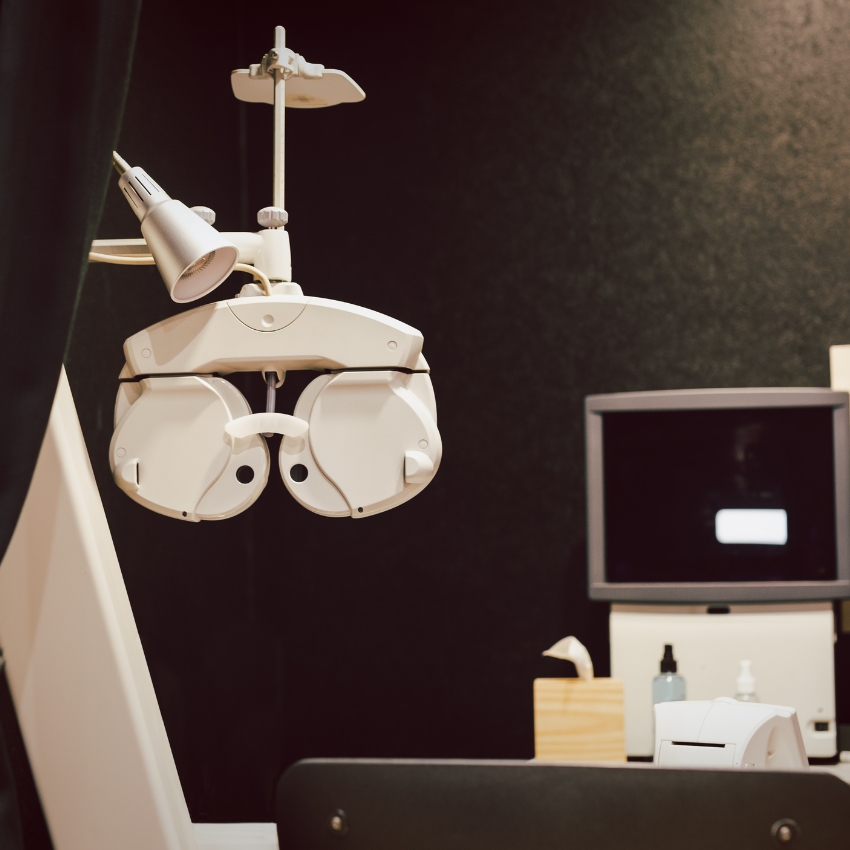 Optometry phoropter machine used for eye exams, with adjustable lenses and dials.