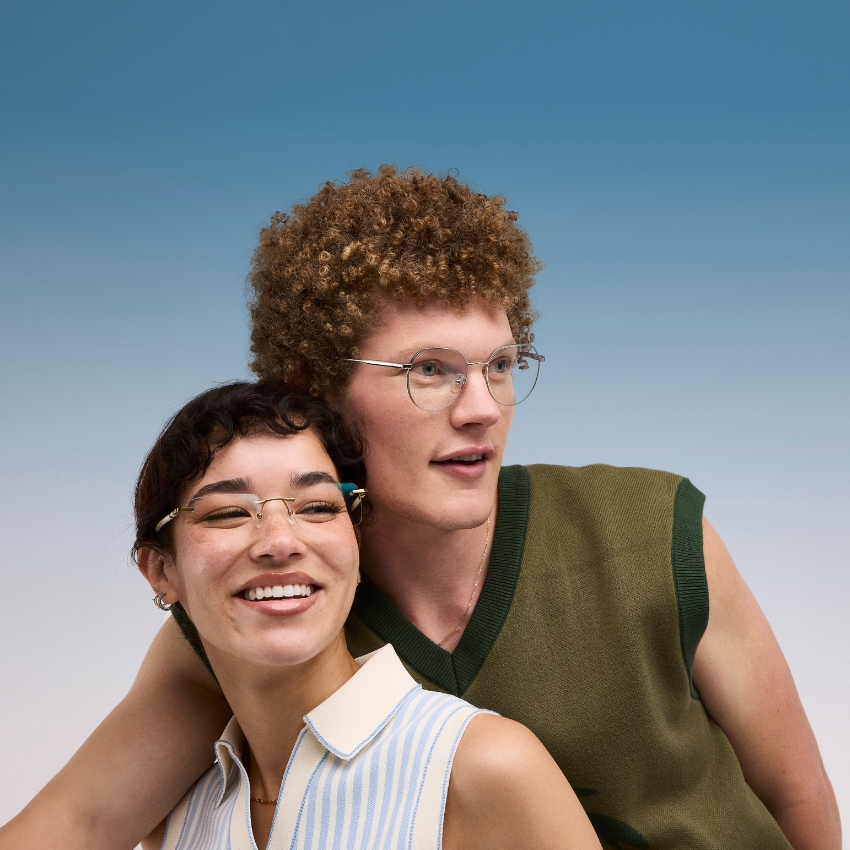 Two people smiling and wearing stylish, thin-framed eyeglasses.