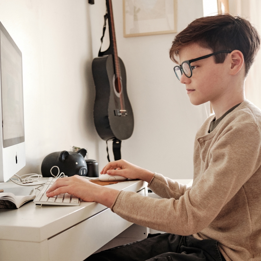 Boy using a desktop computer with a wireless keyboard and mouse