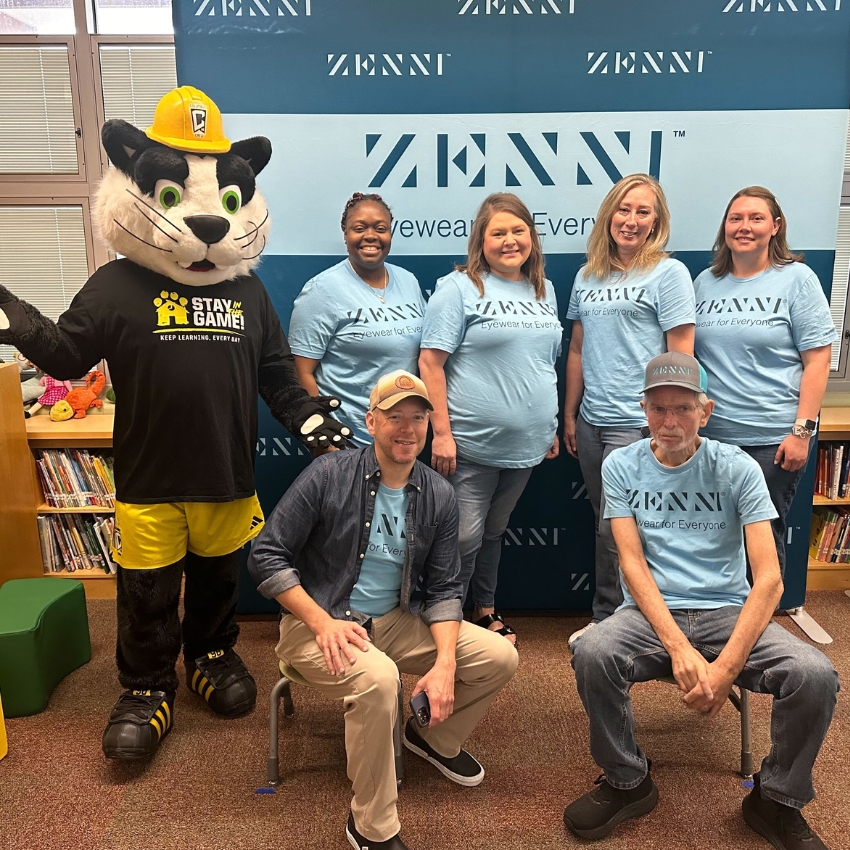 Zenni Eyewear event featuring staff and a mascot wearing a "Stay in the Game, Keep Learning Every Day" shirt.