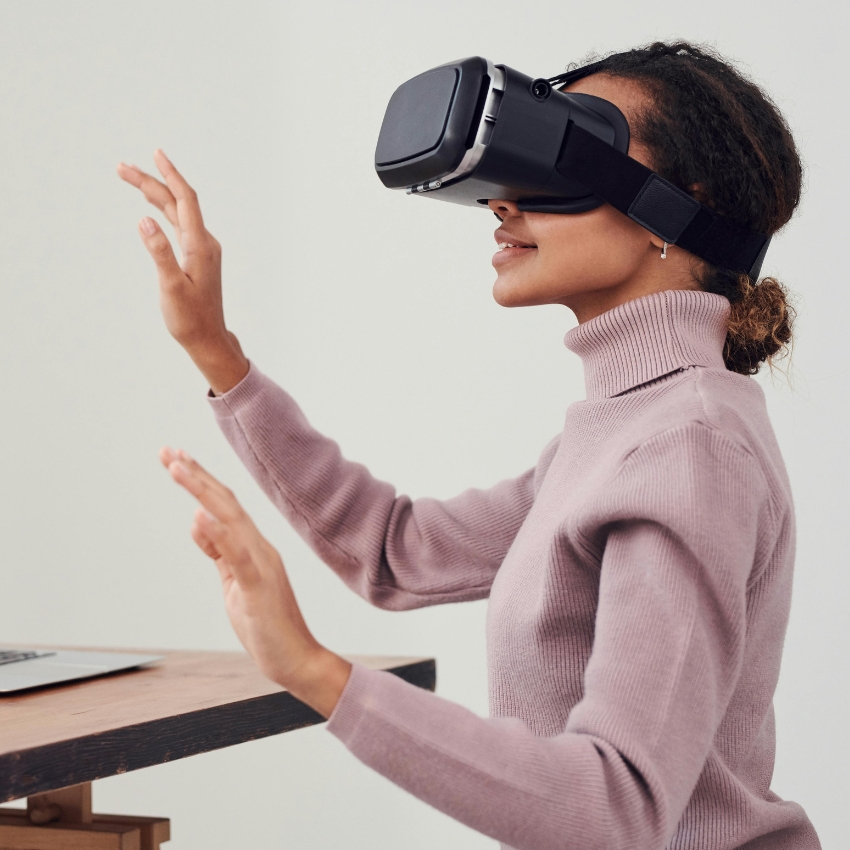 Person wearing a VR headset, hands raised as if interacting with a virtual environment.