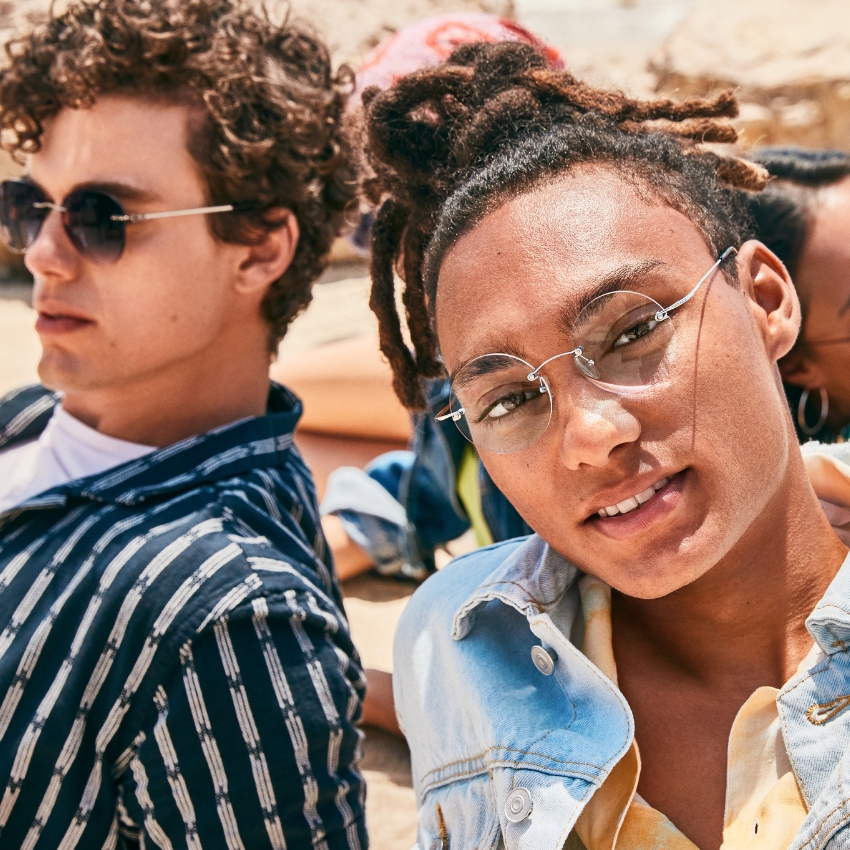 Two people wearing stylish sunglasses; one with round lenses and one with dark, rectangular lenses.