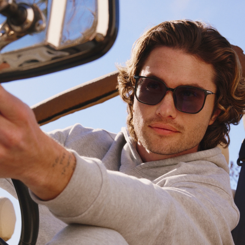 Man wearing black sunglasses and a gray hoodie.