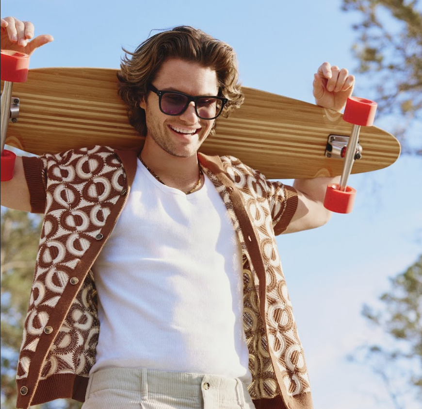 A longboard with a wooden deck and red wheels.