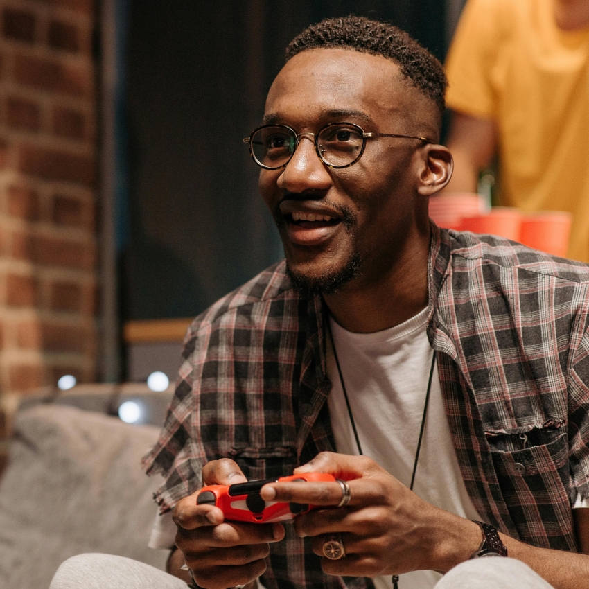 Man holding a red and black game controller.