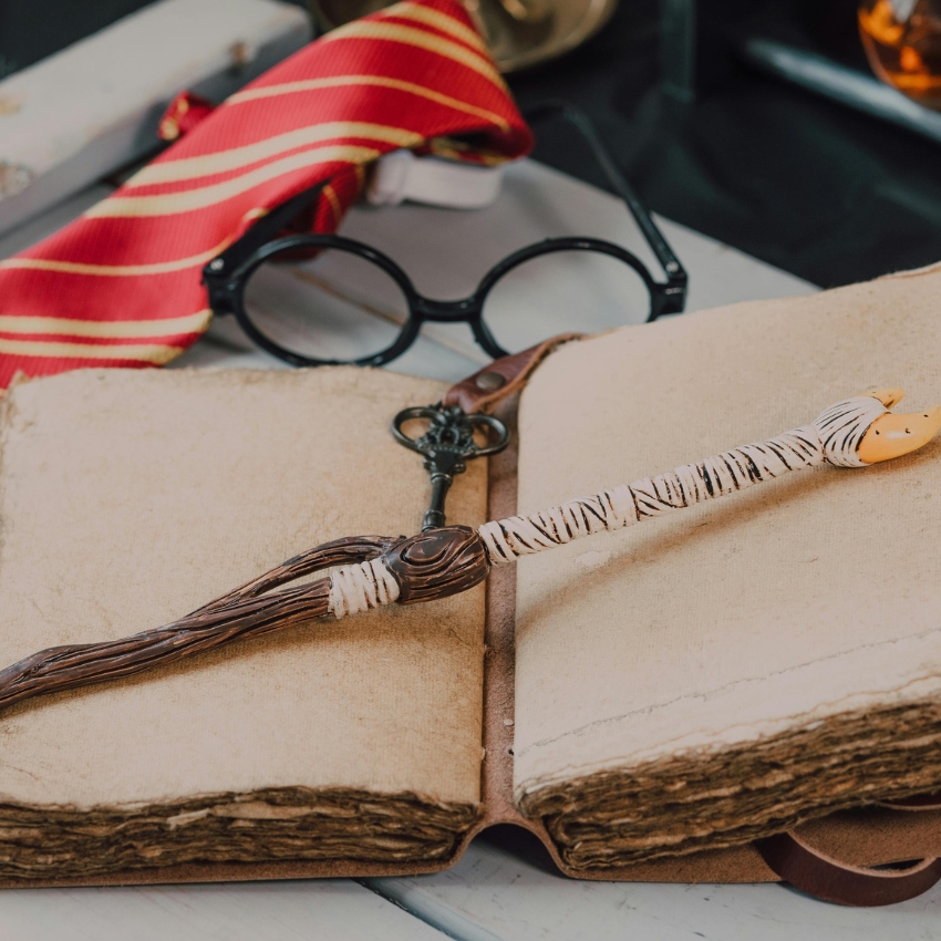 Decorative wand on an open vintage book with textured pages.