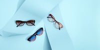 Three pairs of eyeglasses with distinct frames on a light blue background.