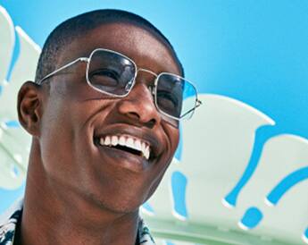 Image of a man wearing Zenni sunglasses outside, smiling.