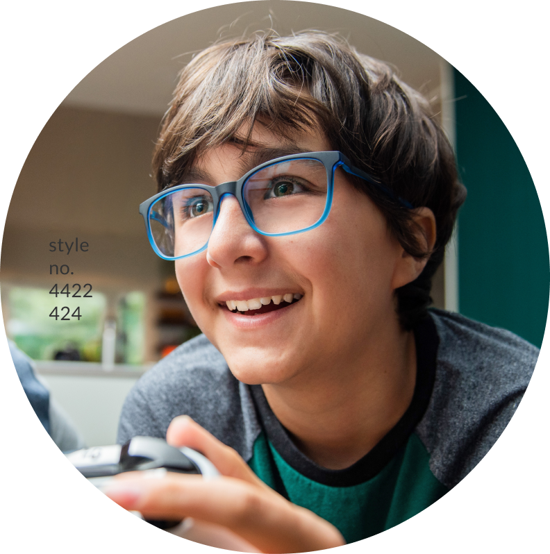 Image of an adolescent boy wearing blue frames, smiling and playing video games.