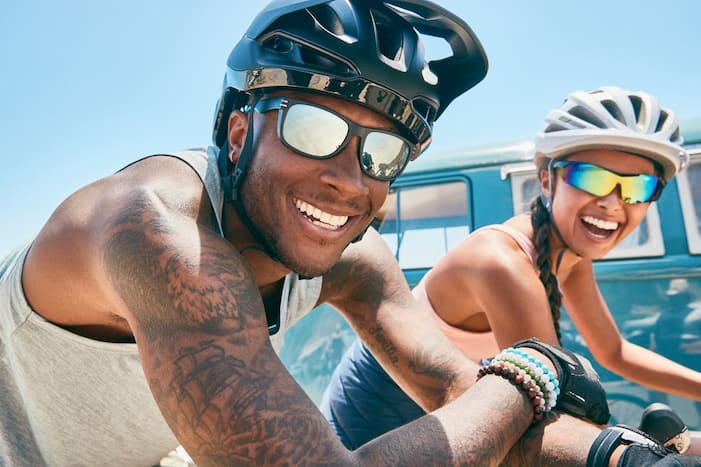  Image of a man and a woman bike riding, wearing Zenni sports sunglasses.
